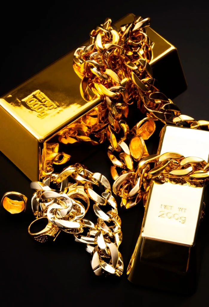 Shiny gold bars with a chunky gold chain draped over them on a black background.